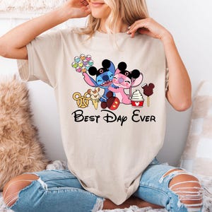 A woman wearing a t-shirt with a cartoon character design and text that says "Best Day Ever".