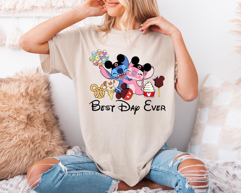 A woman wearing a t-shirt with a cartoon character design and text that says "Best Day Ever".