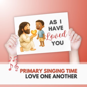 Peut inclure: Une carte blanche tenue par des mains présente une illustration de Jésus donnant un cœur doré à un enfant. Le texte dit « AS I HAVE Loved YOU » et « PRIMARY SINGING TIME LOVE ONE ANOTHER ». Des notes de musique sont dans le coin inférieur gauche.