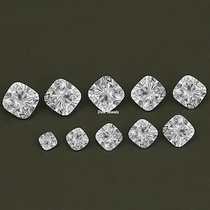K&ouml;nnte beinhalten: Eine Sammlung von zehn klaren, facettierten, quadratischen Diamanten in verschiedenen Gr&ouml;&szlig;en. Die Diamanten sind in einer Reihe angeordnet, wobei der gr&ouml;&szlig;te Diamant in der Mitte liegt.