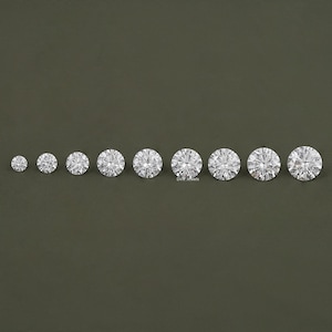 May include: A set of ten round, clear, faceted gemstones of varying sizes. The gemstones are arranged in a row from smallest to largest.
