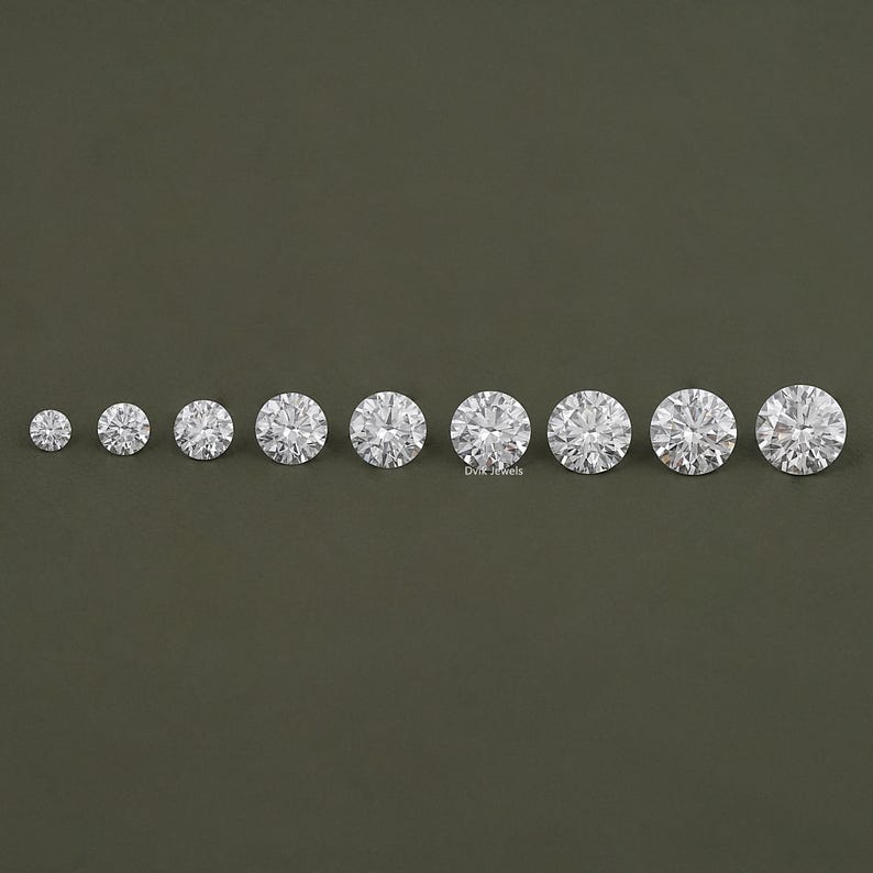 May include: A set of ten round, clear, faceted gemstones of varying sizes. The gemstones are arranged in a row from smallest to largest.