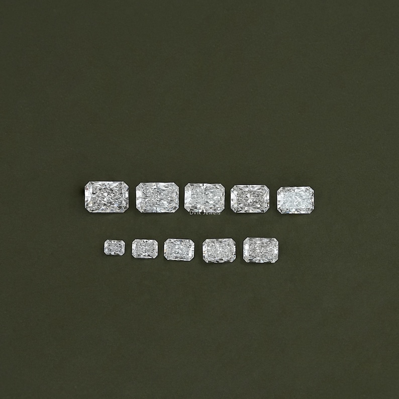 May include: A set of ten clear, faceted, rectangular gemstones of varying sizes. The gemstones are arranged in two rows, with the larger gemstones in the top row and the smaller gemstones in the bottom row.