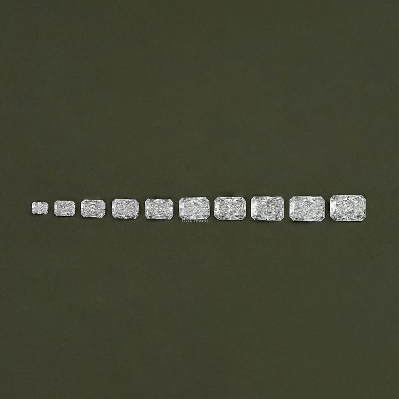 May include: A row of ten clear, rectangular, faceted gemstones of varying sizes, arranged from smallest to largest on a green background.