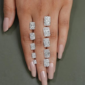May include: A set of ten rectangular cut diamonds of varying sizes, displayed on a hand with fair skin.