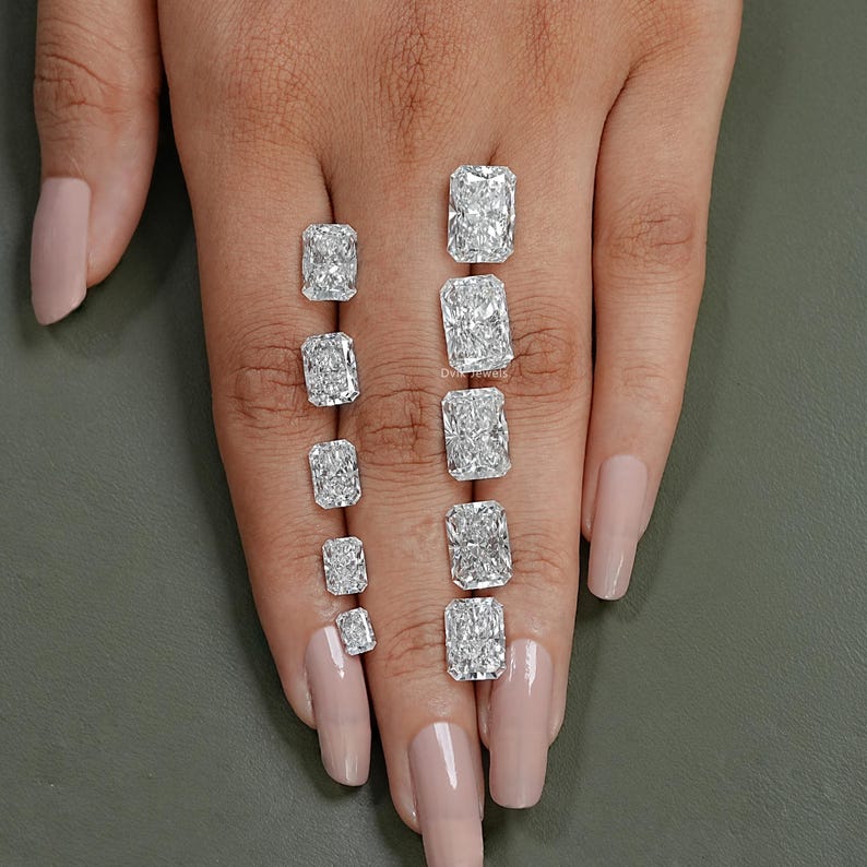 May include: A set of ten rectangular cut diamonds of varying sizes, displayed on a hand with fair skin.