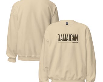 May include: Cream-colored sweatshirt with the text "JAMAICAN" in a black, rectangular font. The sweatshirt is shown from the front and back, highlighting its simple design and neutral color. The text "BY ASSOCIATION" is below the word "JAMAICAN".