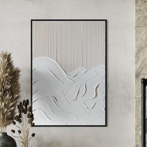 Pode incluir: Uma pintura abstrata texturizada branca em uma moldura preta pendurada em uma parede cinza claro. A pintura apresenta uma série de linhas e curvas brancas, criando uma sensação de movimento e profundidade. Duas plantas de capim-das-pampas secas em vasos cinzentos são colocadas no chão em frente à pintura.