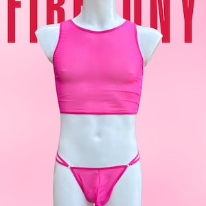 Può includere: Un completo composto da crop top e perizoma rosa acceso su un manichino. Il top è senza maniche, a collo alto. Il perizoma presenta sottili spalline con piccoli dettagli bianchi. La parola "FIREPONY" è stampata in rosso in alto.