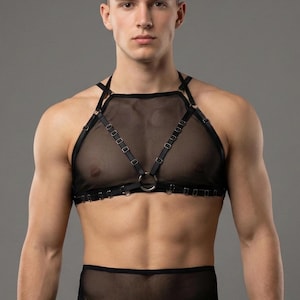 以下が含まれることがあります： メッシュパネルと金属リングのアクセントが特徴の黒いランジェリーセット。セットには、同様のメッシュとリングのディテールが施されたお揃いのボトムが含まれています。全体的なデザインは、ミニマリストの美学に焦点を当てた、洗練されたモダンなものです。