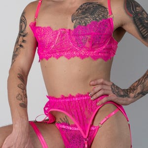Pode incluir: Conjunto de lingerie rosa choque com sutiã de renda com aros e cinta-liga a condizer. O conjunto inclui alças ajustáveis e detalhes delicados em renda. Um conjunto vibrante e apelativo.