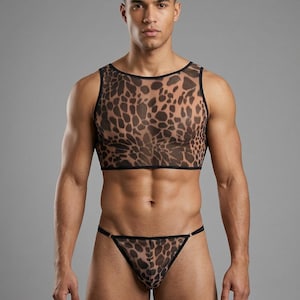 Può includere: Un completo composto da top corto senza maniche e perizoma trasparente con stampa leopardata marrone e nera, bordato di nero. Il modello è su sfondo grigio.