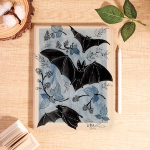 May include: A decorative tablet case featuring a watercolor design of black bats, blue leaves, and berries on a light blue background. The case has a cream-colored border. A white stylus is placed on the right side of the case.