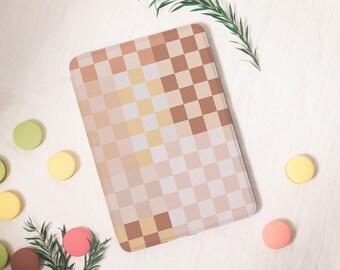May include: A rectangular, checkered pattern notebook cover in shades of beige, brown, and yellow. The cover is surrounded by colorful, circular decorations and a sprig of greenery, creating a soft, pastel aesthetic.