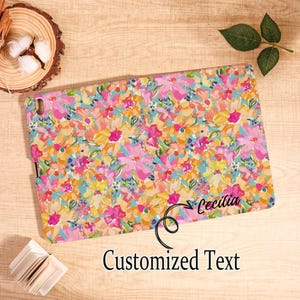 May include: A tablet case with a vibrant floral pattern in pink, yellow, orange, and blue. The case has the name "Cecilia" and the words "Customized Text" printed on it. The case is rectangular.