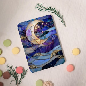 May include: A rectangular decorative item with a stained-glass effect, depicting a crescent moon and stars against a blue and purple background. Gold detailing enhances the celestial theme. Likely a decorative mat or pad, with a night sky design.