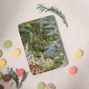 May include: A rectangular decorative tray featuring a whimsical garden scene with a frog, mushrooms, and a flowing stream. The artwork includes colorful flowers and lily pads, with a soft, vintage aesthetic.