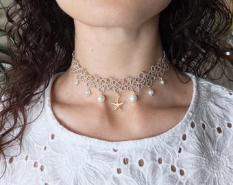 Collana girocollo in pizzo chiacchierino color avorio, con gocce di perle e ciondolo a forma di stella marina, stile spiaggia.