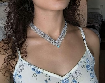 Collana girocollo in pizzo blu con lavorazione a chiacchierino: filo metallico argentato e cristalli.