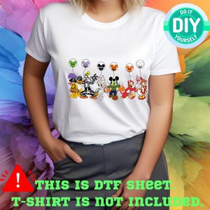 a woman wearing a white tshirt with mickey mouse and friends on it