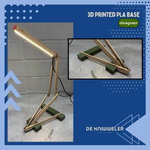 May include: A unique desk lamp made from wooden folding rulers and an olive green 3D printed base. The lamp features a bright LED light and is connected to a power source. The text "3D PRINTED PLA BASE" and "olivegreen" are visible.