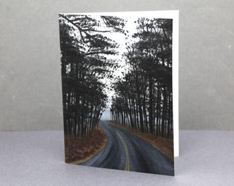 May include: A folded greeting card featuring a watercolor painting of a road winding through a forest. The trees are dark, and the road has yellow lines. The sky is overcast.