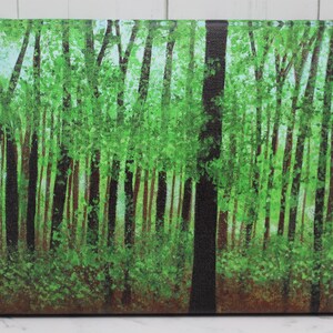 Puede incluir: Pintura rectangular sobre lienzo que representa una escena de bosque. Los troncos de los árboles, altos y delgados, en tonos marrón y negro, se alzan desde abajo, con un follaje verde vibrante en la parte superior. El fondo es azul claro.
