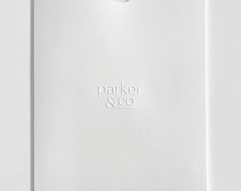 May include: A white paper envelope with a curved top flap. The embossed text "parker & co" is centered on the front. The envelope is rectangular and has a minimalist design.