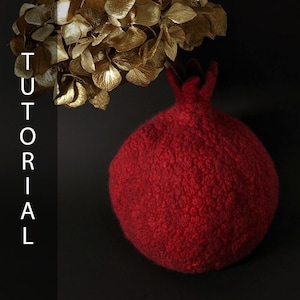 May include: A handcrafted, red pomegranate-shaped decorative item with a textured surface. The word "TUTORIAL" is vertically displayed in white letters on the left side of the image. Gold-colored dried flowers are in the background.