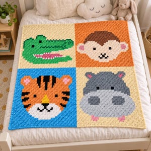 May include: A square crochet blanket featuring four distinct animal faces in a grid pattern. The top left shows a green crocodile, the top right a brown monkey, the bottom left an orange tiger, and the bottom right a gray hippopotamus.