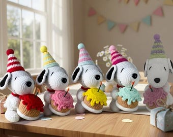 May include: Five white crocheted dog figures, each wearing a colorful striped party hat and holding a small crocheted cupcake with a single candle. The figures have black ears, black noses, and are arranged in a row on a wooden surface.