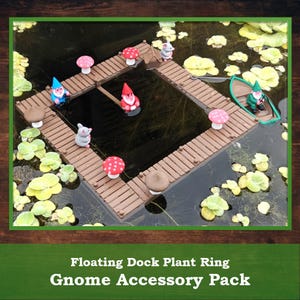 May include: A miniature floating dock plant ring with gnome accessories. The scene includes a small boat, gnomes, mushrooms, and mice on a brown wooden dock. The text at the bottom reads "Floating Dock Plant Ring Gnome Accessory Pack."