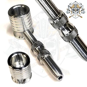 Puede incluir: Una pipa para fumar de metal plateado con una cazoleta y una boquilla larga y estrecha. La pipa tiene un diseño texturizado y un pequeño agujero en el extremo de la boquilla.