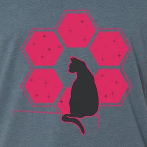 Op de afbeelding: Een zwart katten silhouet dat voor een roze honingraatpatroon met witte sterren zit.