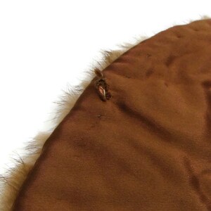 K&ouml;nnte beinhalten: Ein brauner Pelzkragen mit braunem Satin-Futter. Der Kragen hat eine kleine Schlaufe auf der R&uuml;ckseite.