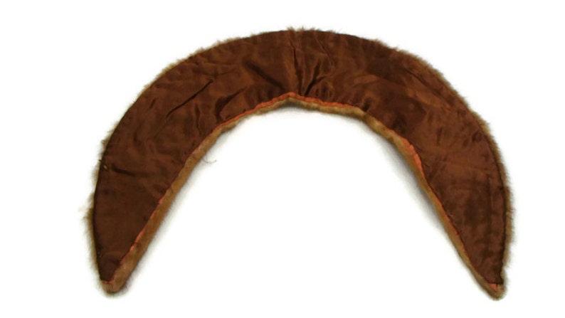 K&ouml;nnte beinhalten: Ein brauner Pelzkragen mit braunem Satin-Futter. Der Kragen ist gebogen und hat eine abgerundete Form.