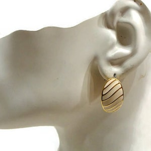 Puede incluir: Pendientes ovalados de oro con un diseño de rayas blancas.