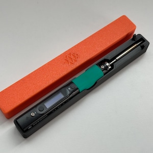 May include: A black and green soldering iron with a digital display and a red carrying case.