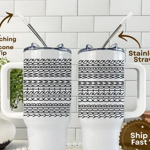 May include: Two white tumblers with black geometric patterns and handles. Each tumbler has a stainless steel straw and a matching silicone tip. The text "Printed on both sides" is visible.