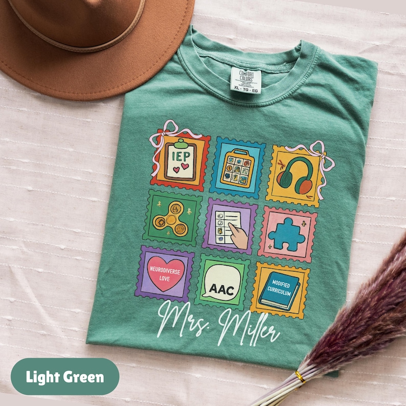 May include: Light green t-shirt with a colorful stamp design featuring educational symbols and the text "Mrs. Miller." The shirt also has the text "Light Green" at the bottom.