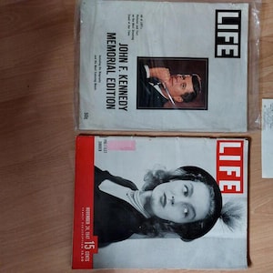 May include: Two vintage Life magazines and a commemorative envelope. One magazine is a John F. Kennedy Memorial Edition with a portrait. The other is a November 1947 issue featuring a black and white portrait of a person wearing a dark beret.