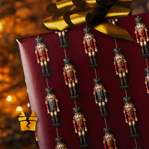 Op de afbeelding: Een ingepakt cadeau met een bordeauxrode achtergrond en een gouden strik. Het cadeaupapier is bedrukt met speelgoednotenkrakers in rode, zwarte en blauwe uniformen. De notenkrakers zijn verbonden door een gouden ketting.
