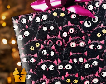 Könnte beinhalten: Ein Geschenk, verpackt in schwarzem Papier mit einem sich wiederholenden Muster von Cartoon-Schwarzen Katzen mit rosa Ohren und Akzenten. Das Geschenk ist mit einer großen, magentafarbenen Schleife versehen.