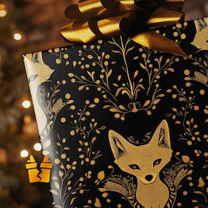 May include: A wrapped gift with a black background and a gold fox and floral pattern. The gift is topped with a large gold bow. The wrapping paper features a repeating pattern of foxes and botanical elements.
