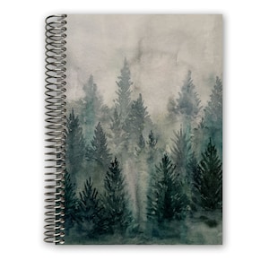 May include: A watercolor painting of a misty forest with tall, dark green trees. The painting is on a spiral bound notebook.