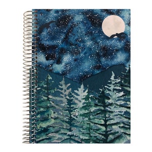 May include: A spiral bound notebook with a watercolor design of a starry night sky with a full moon and a forest of pine trees in the foreground.