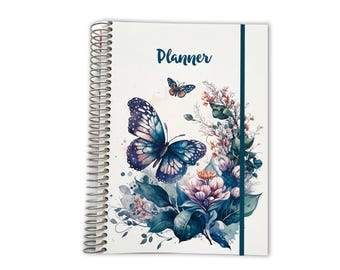 May include: A spiral-bound planner with a white cover featuring the word Planner in dark blue text. The design includes a large blue and purple butterfly, a smaller orange butterfly, and a cluster of watercolor-style flowers and green leaves.