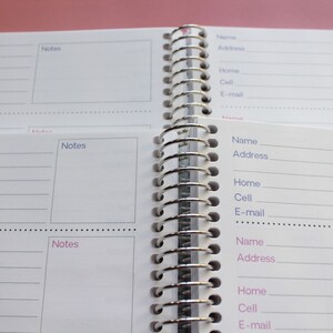 an open spiral-bound notebook with two pages visible, one of which has a blank space for notes and the other for contact information.