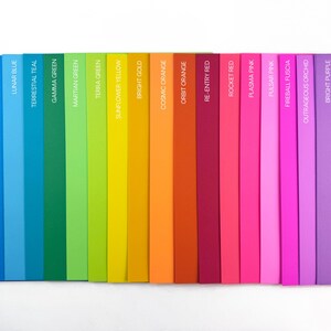 May include: A colourful spectrum of hues, ranging from deep blues to vibrant purples. Each colour is labelled with its name, including "Blast Off Blue," "Celestial Blue," and "Venus Violet." The arrangement showcases a gradient of shades.