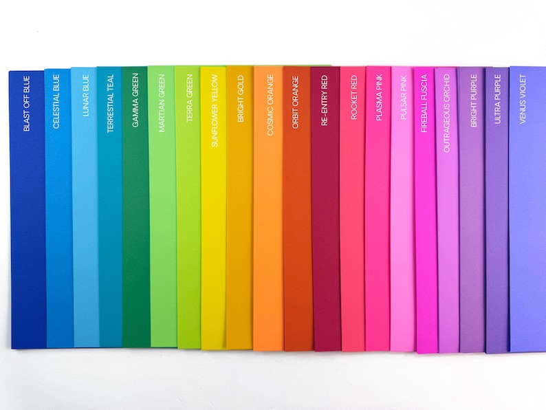 May include: A colourful spectrum of hues, ranging from deep blues to vibrant purples. Each colour is labelled with its name, including "Blast Off Blue," "Celestial Blue," and "Venus Violet." The arrangement showcases a gradient of shades.
